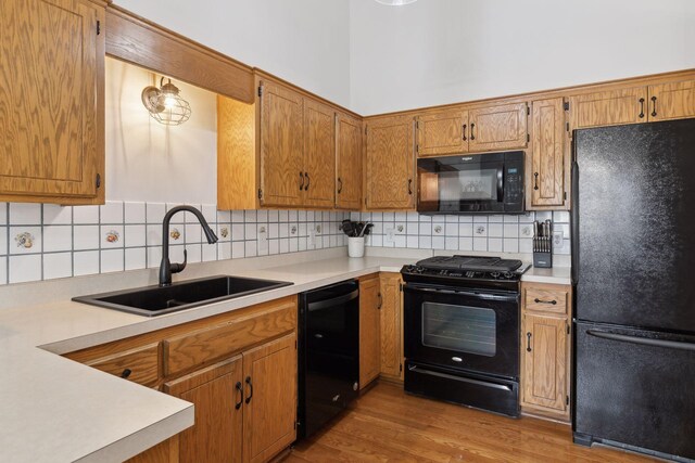 14870 Endicott Way Unit 20, Apple Valley, MN 55124 - kitchen featuring black appliances, a sink, light countertops, decorative backsplash, and wood finished floors