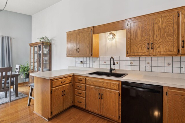 14870 Endicott Way Unit 20, Apple Valley, MN 55124 - kitchen featuring dishwasher, a sink, a peninsula, decorative backsplash, and light wood finished floors