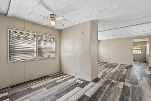 501 Forest St Unit 18, Belle Plaine, MN 56011 - spare room featuring ceiling fan, wood finished floors, a textured ceiling, and wood walls