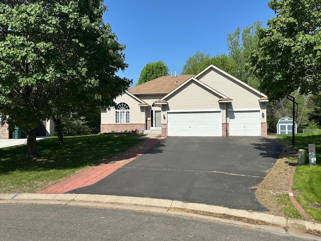 view of front facade with brick siding, a garage, driveway, a storage shed, and a front lawn