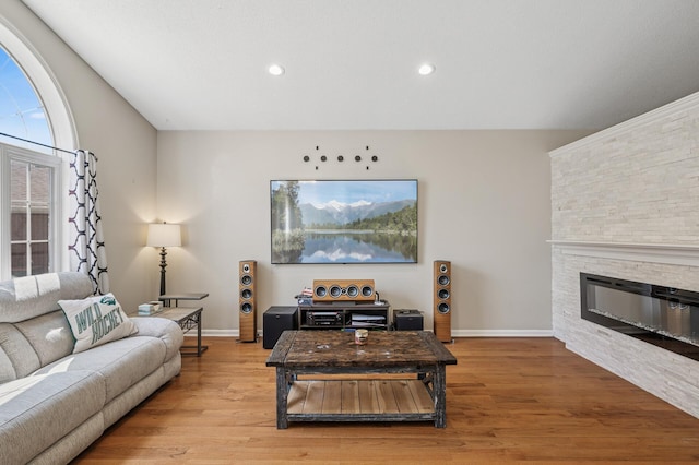 living room featuring baseboards, wood finished floors, recessed lighting, and a fireplace