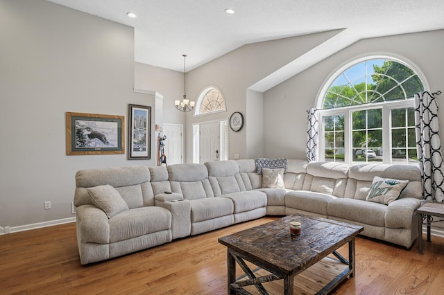 living room featuring a chandelier, wood finished floors, recessed lighting, baseboards, and high vaulted ceiling