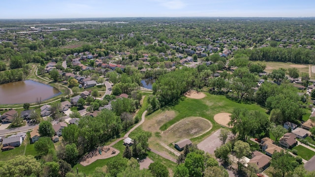 aerial view of property's location with a nearby body of water, nearby suburban area, and a golf course