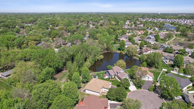 aerial view of property's location featuring a large body of water, nearby suburban area, and a forest