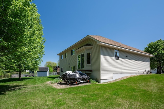 view of home's exterior with a lawn, a shed, and an outbuilding