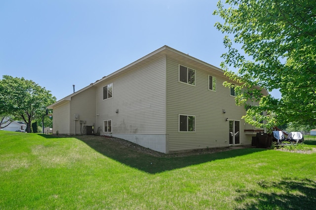 view of property exterior with central air condition unit and a lawn