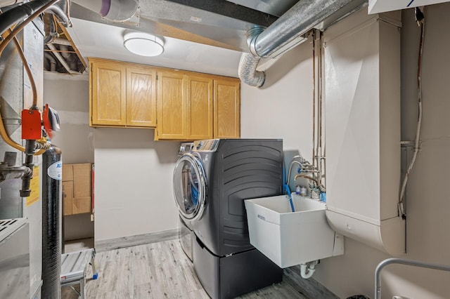 laundry area featuring cabinet space and light wood-style floors