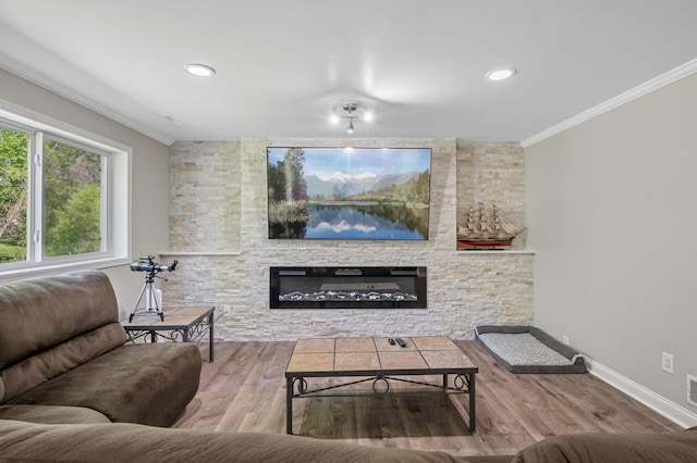 living area featuring a fireplace, ornamental molding, baseboards, and wood finished floors