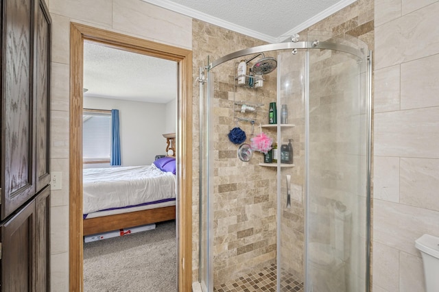 ensuite bathroom featuring a textured ceiling, crown molding, and a stall shower