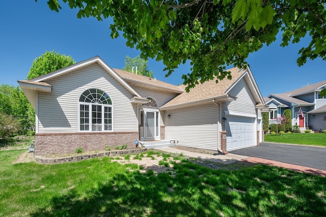 view of front facade featuring brick siding, a front lawn, a garage, and driveway