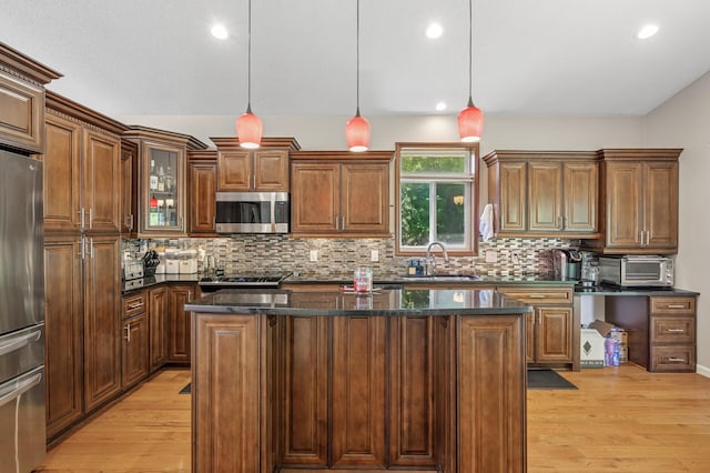 kitchen featuring stainless steel appliances, a sink, light wood-type flooring, a center island, and recessed lighting