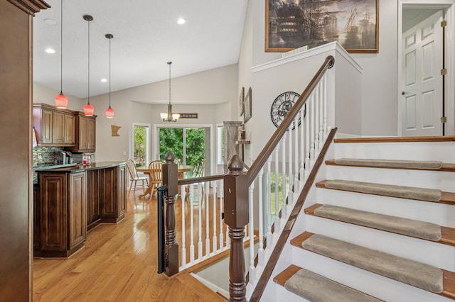 staircase with wood finished floors, lofted ceiling, and recessed lighting