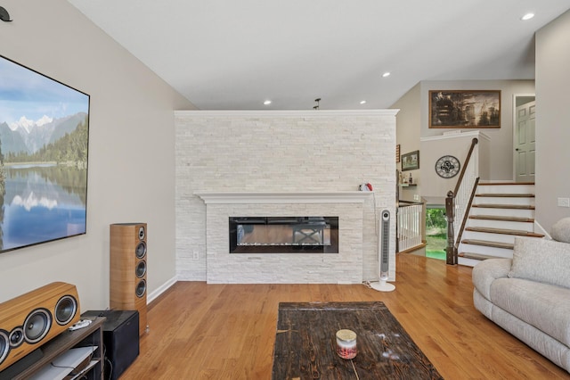 living room featuring wood finished floors, stairway, a fireplace, and recessed lighting