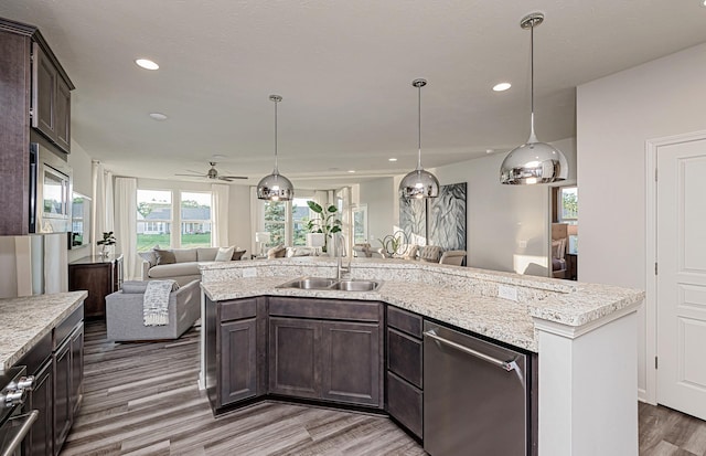 9997 Mulberry Ln, Corcoran, MN 55374 - kitchen featuring appliances with stainless steel finishes, open floor plan, a sink, dark brown cabinetry, and wood finished floors