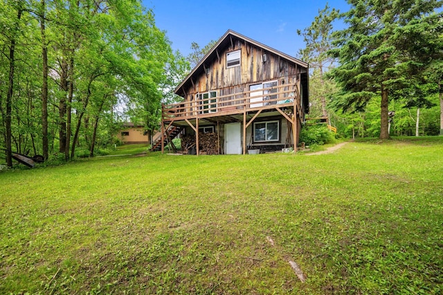 back of property featuring stairs, a deck, and a yard