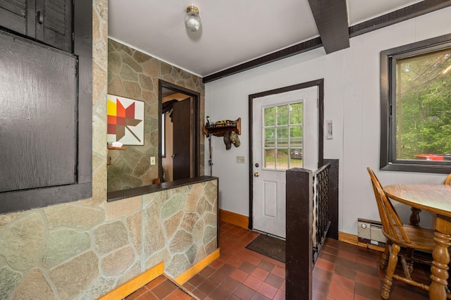 entrance foyer featuring crown molding, dark tile patterned flooring, and baseboards