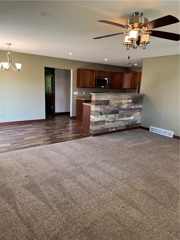 169 Amber View St, Menomonie, WI 54751 - unfurnished living room featuring baseboards, dark carpet, a ceiling fan, a chandelier, and recessed lighting