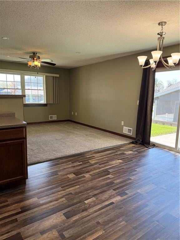 169 Amber View St, Menomonie, WI 54751 - spare room with dark wood finished floors, a textured ceiling, a chandelier, and baseboards