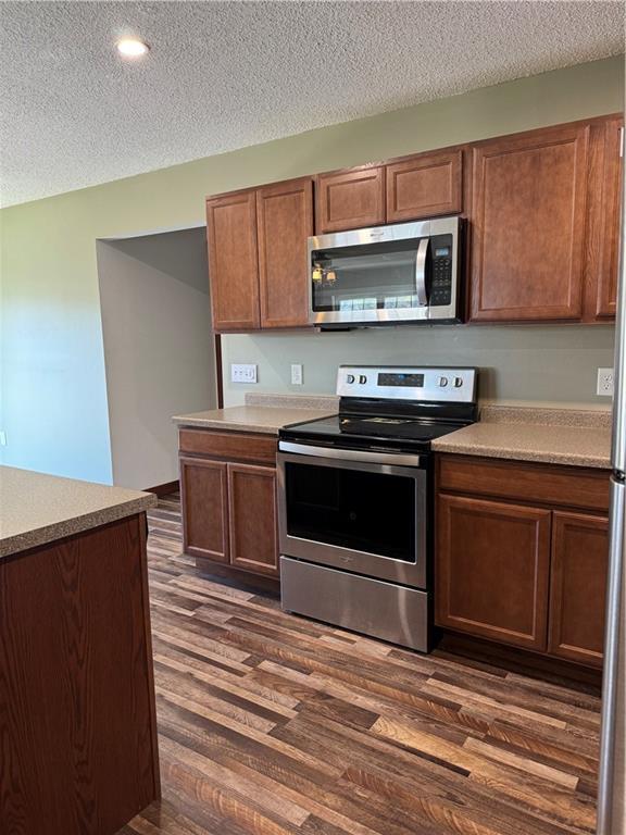 169 Amber View St, Menomonie, WI 54751 - kitchen featuring stainless steel appliances, dark wood-style flooring, a textured ceiling, light countertops, and recessed lighting