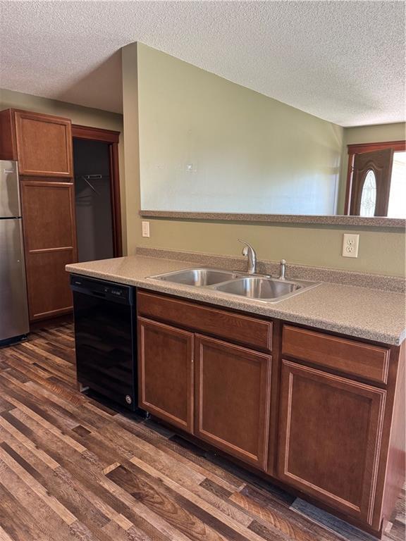 169 Amber View St, Menomonie, WI 54751 - kitchen featuring freestanding refrigerator, dishwasher, a sink, a textured ceiling, and dark wood-type flooring