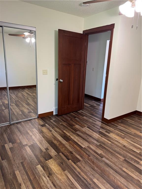 169 Amber View St, Menomonie, WI 54751 - unfurnished bedroom with wood finished floors, baseboards, ceiling fan, a closet, and a textured ceiling
