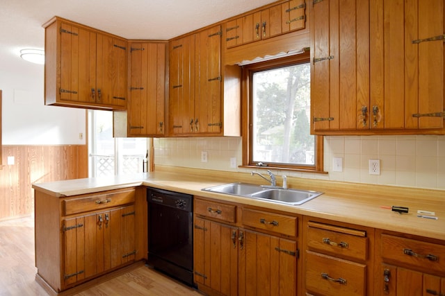 kitchen featuring dishwasher, a sink, and light countertops