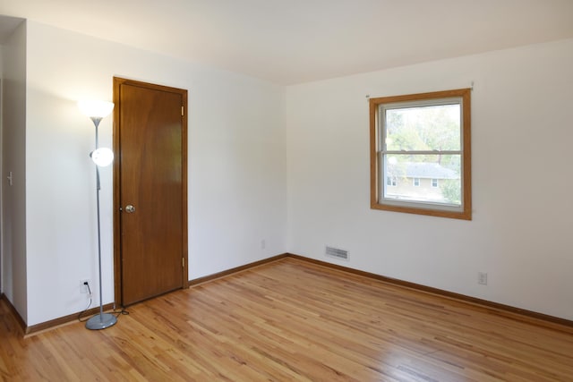 spare room with light wood-style flooring and baseboards