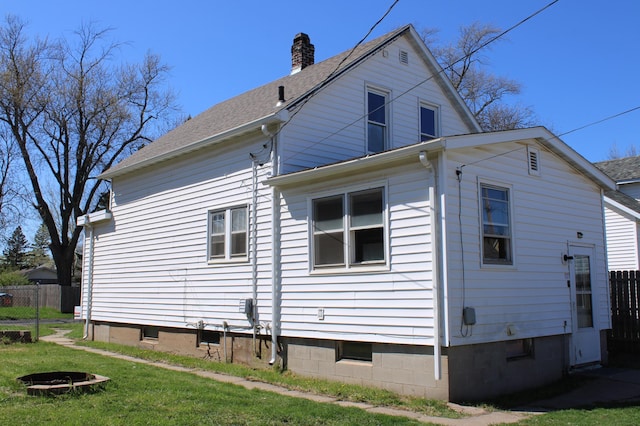 2612 3rd Ave W, Hibbing, MN 55746 - view of side of home featuring a chimney, an outdoor fire pit, and a shingled roof
