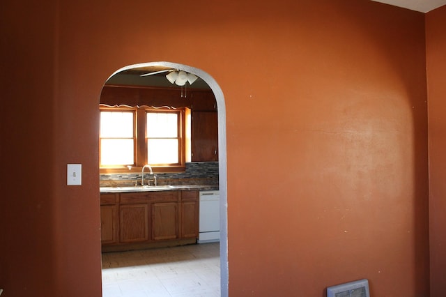 2612 3rd Ave W, Hibbing, MN 55746 - kitchen featuring dishwasher, arched walkways, and brown cabinets