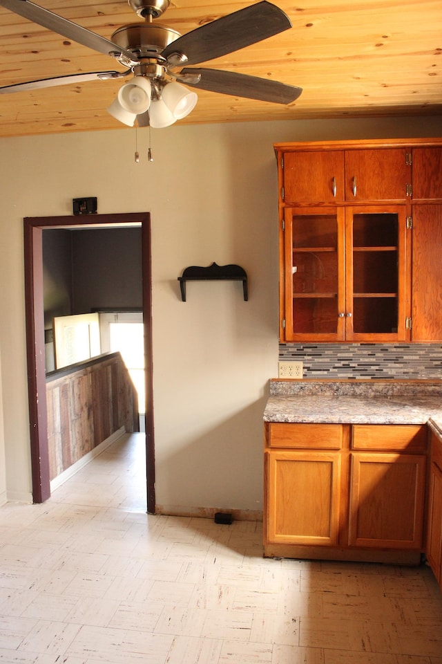 2612 3rd Ave W, Hibbing, MN 55746 - kitchen featuring ceiling fan, brown cabinets, tasteful backsplash, and glass insert cabinets