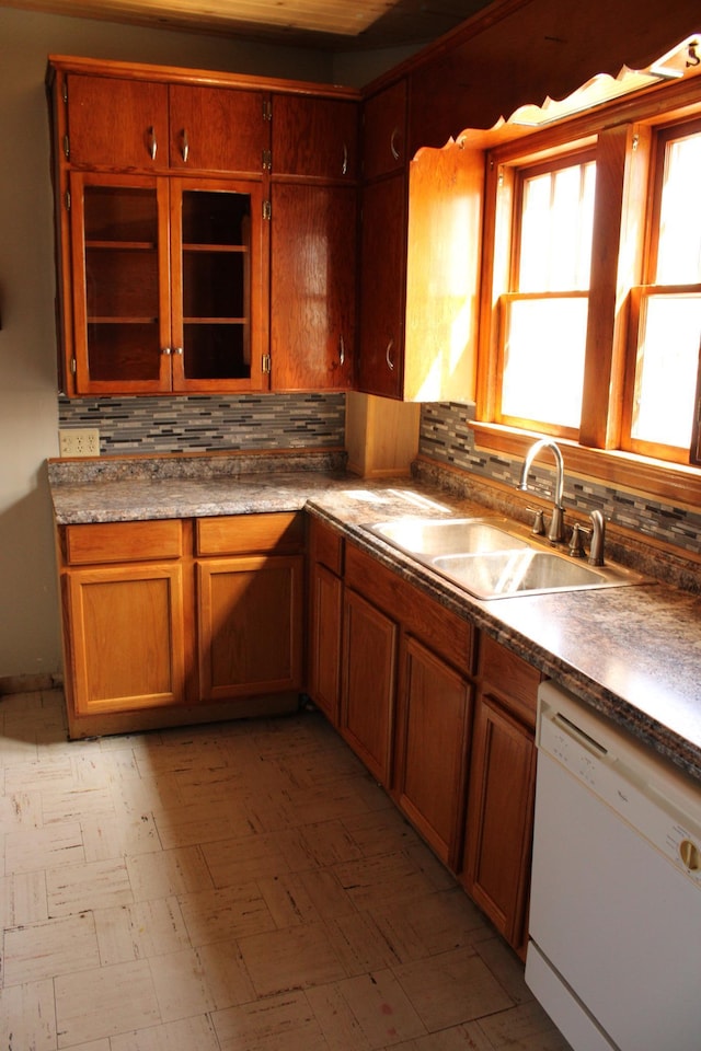 2612 3rd Ave W, Hibbing, MN 55746 - kitchen featuring white dishwasher, tasteful backsplash, light flooring, and brown cabinetry