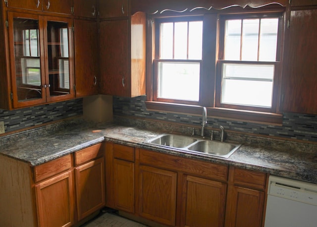 2612 3rd Ave W, Hibbing, MN 55746 - kitchen with white dishwasher, backsplash, brown cabinetry, and dark countertops