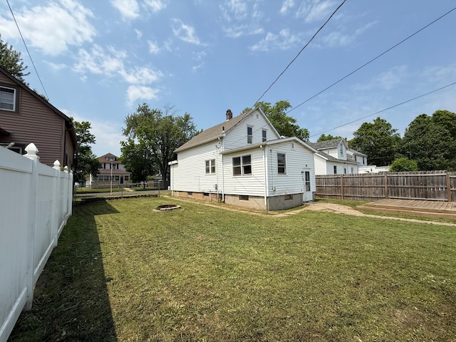 2612 3rd Ave W, Hibbing, MN 55746 - back of house with a fenced backyard, crawl space, an outdoor fire pit, and a chimney
