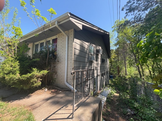 view of side of property featuring brick siding and a patio
