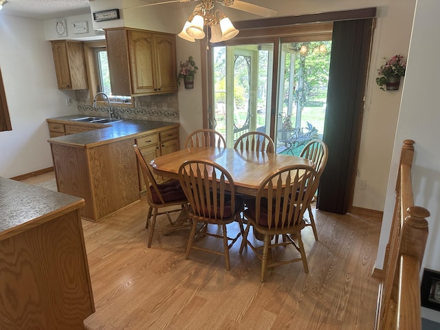 dining space featuring light wood-type flooring, ceiling fan, plenty of natural light, and baseboards
