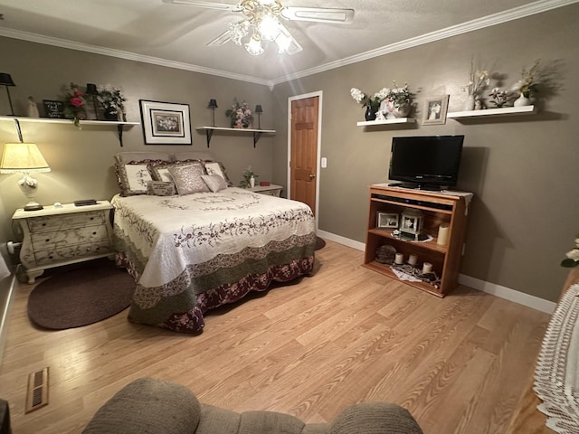 bedroom featuring wood finished floors, ornamental molding, ceiling fan, and baseboards