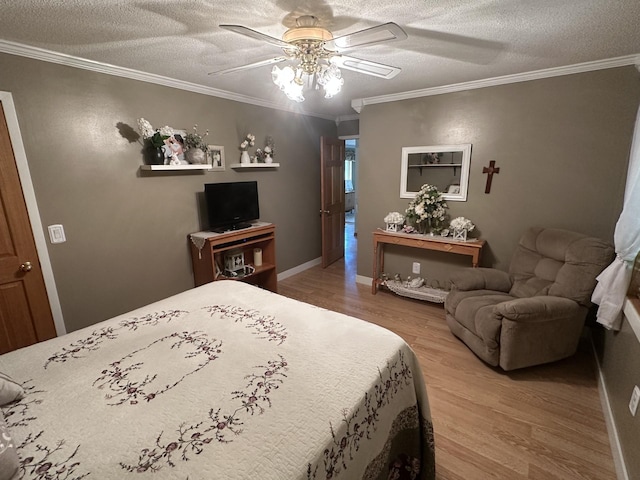bedroom featuring wood finished floors, a textured ceiling, ornamental molding, ceiling fan, and baseboards