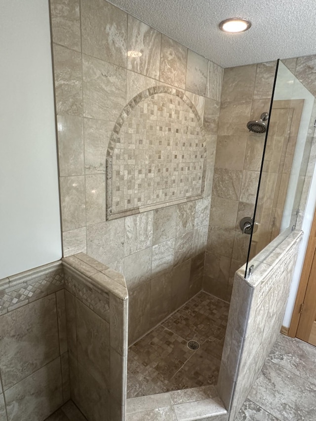 full bathroom with walk in shower and a textured ceiling