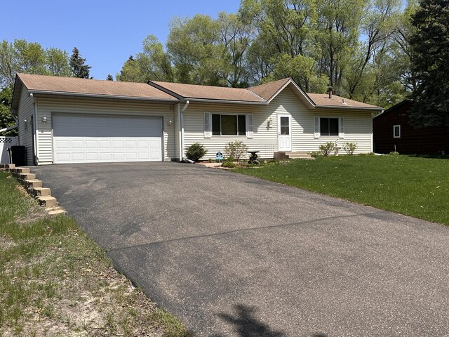 ranch-style house featuring driveway, a garage, and a front yard