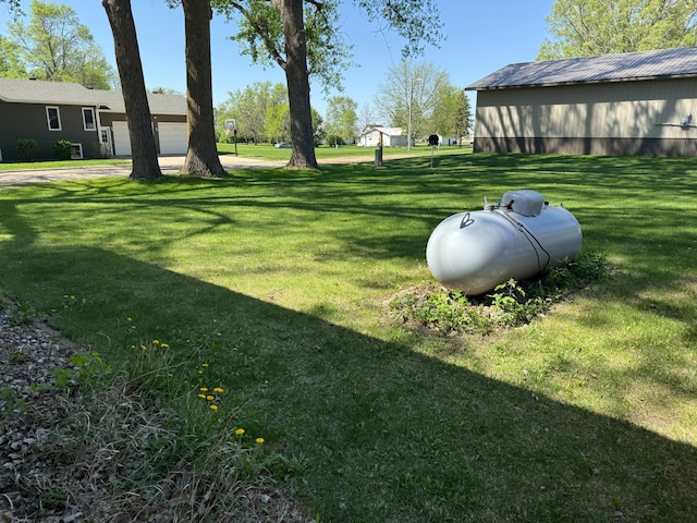 303 4th St S, Hoffman, MN 56339 - view of green lawn featuring driveway and an attached garage