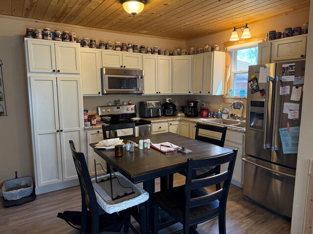 303 4th St S, Hoffman, MN 56339 - kitchen with appliances with stainless steel finishes, a sink, wooden ceiling, wood finished floors, and white cabinets