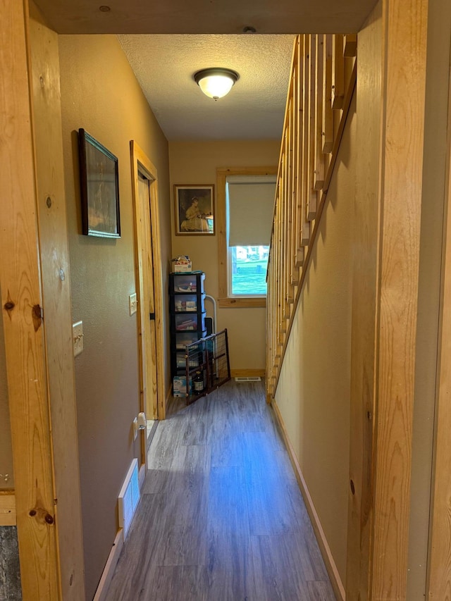303 4th St S, Hoffman, MN 56339 - corridor featuring wood finished floors, baseboards, stairway, and a textured ceiling