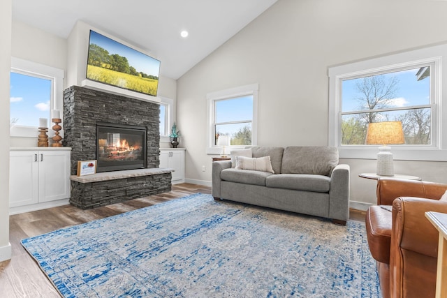 6359 313th Ave NE, North Branch, MN 55056 - living area featuring wood finished floors, a stone fireplace, high vaulted ceiling, baseboards, and recessed lighting