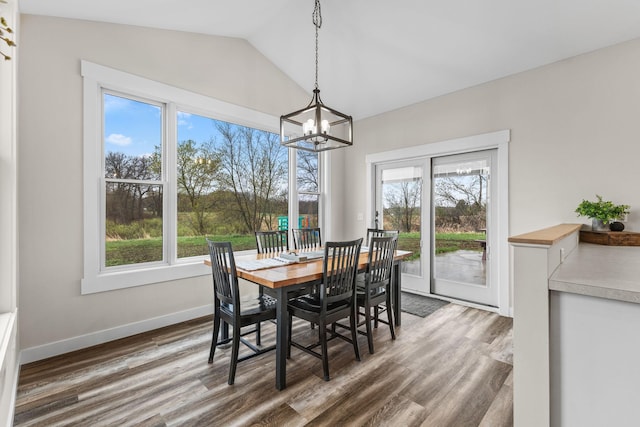 6359 313th Ave NE, North Branch, MN 55056 - dining area featuring a chandelier, plenty of natural light, vaulted ceiling, wood finished floors, and baseboards