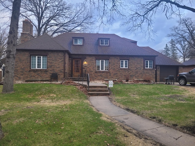view of front of property with brick siding, a chimney, and a front yard