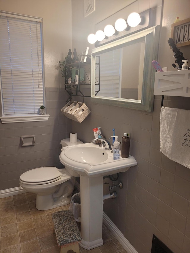 bathroom featuring tile walls, toilet, and tile patterned flooring