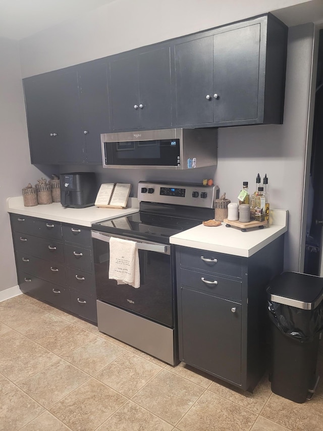 kitchen featuring appliances with stainless steel finishes, light countertops, and baseboards