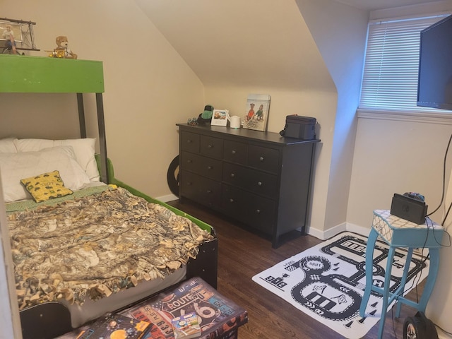 bedroom with dark wood-type flooring, lofted ceiling, and baseboards