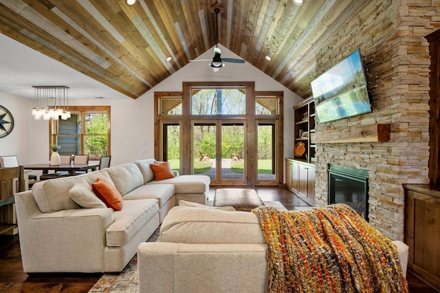 living room featuring plenty of natural light, a stone fireplace, dark wood finished floors, recessed lighting, and wood ceiling