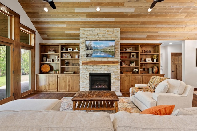 living area featuring wooden ceiling, ceiling fan, wood finished floors, vaulted ceiling, and a stone fireplace